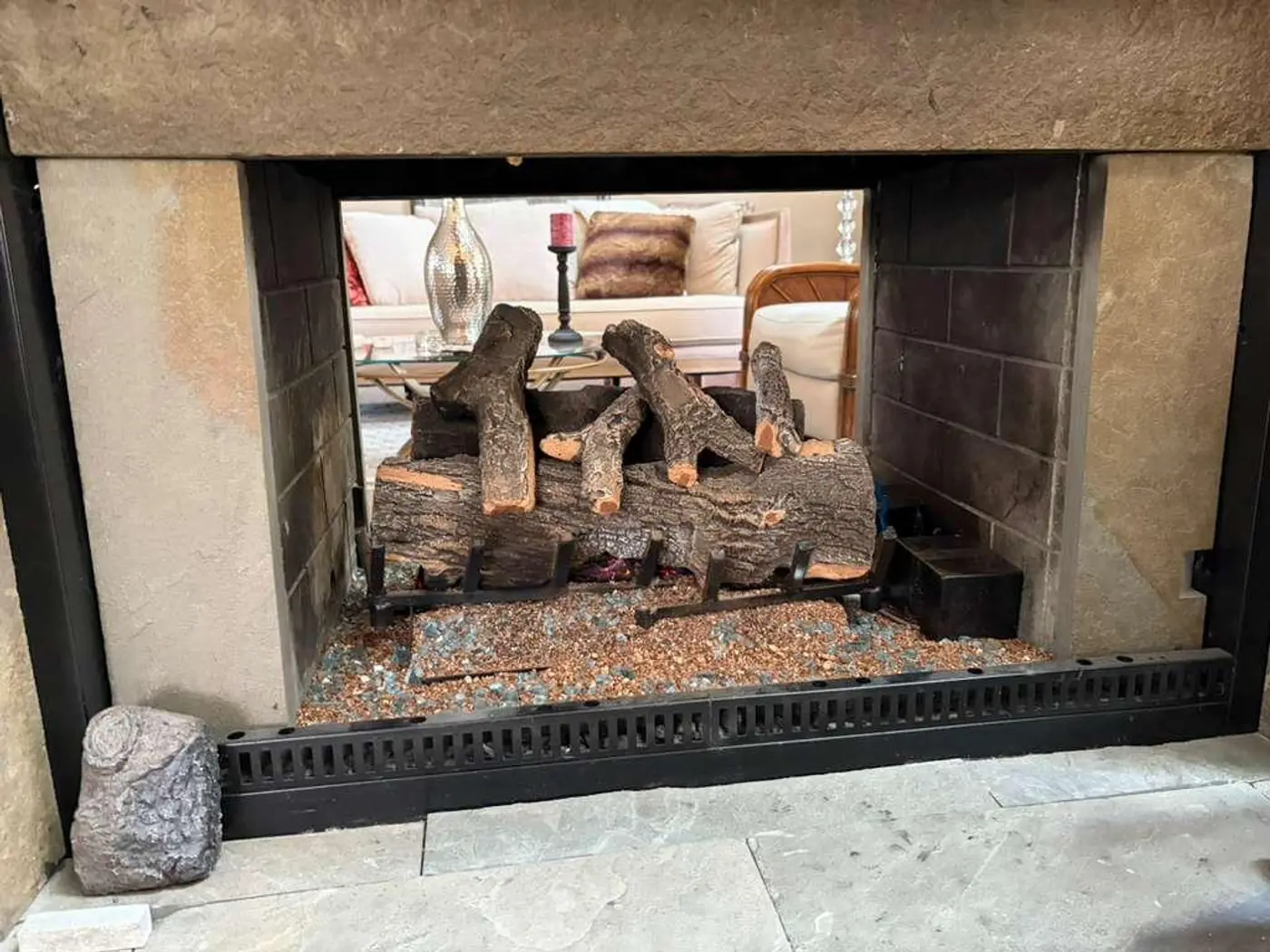 Brick firebox with a gas log set in a furnished living room