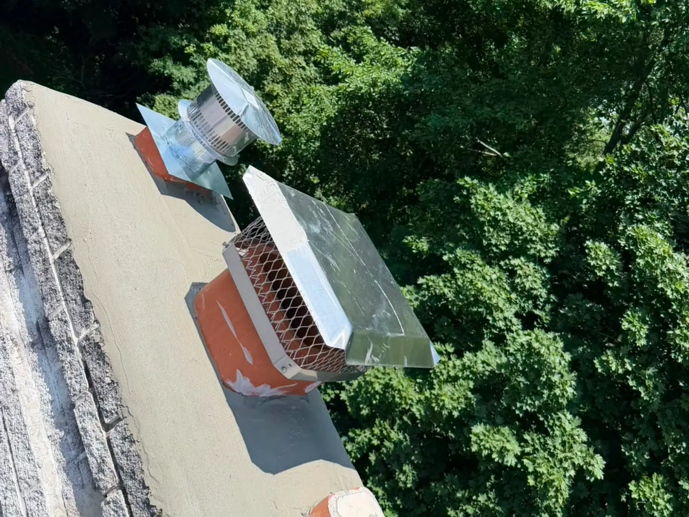 Overhead view of a rebuilt chimney crown with new caps on both flues