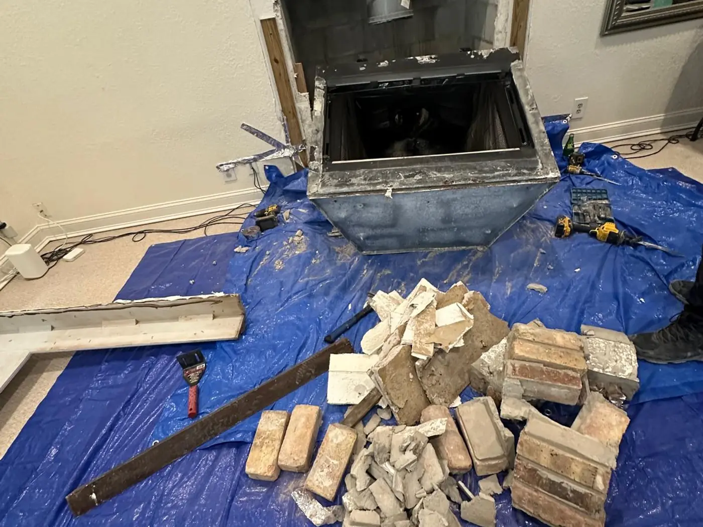 Firebox opened up for rebuilding with old brick removed onto a protective tarp